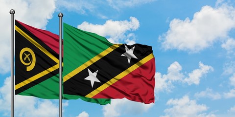 Vanuatu and Saint Kitts And Nevis flag waving in the wind against white cloudy blue sky together. Diplomacy concept, international relations.