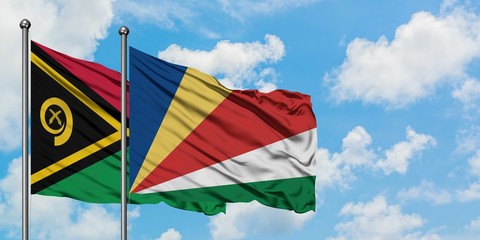 Vanuatu and Seychelles flag waving in the wind against white cloudy blue sky together. Diplomacy...