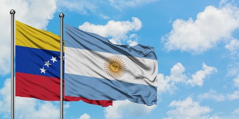 Venezuela and Argentina flag waving in the wind against white cloudy blue sky together. Diplomacy concept, international relations.