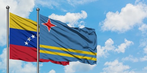 Venezuela and Aruba flag waving in the wind against white cloudy blue sky together. Diplomacy concept, international relations.