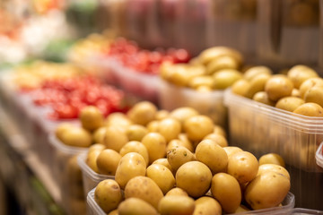 Small potatoes in baskets on street market, closeup selective focus