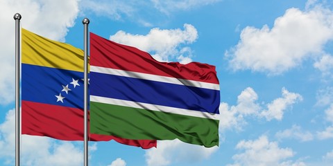 Venezuela and Gambia flag waving in the wind against white cloudy blue sky together. Diplomacy concept, international relations.