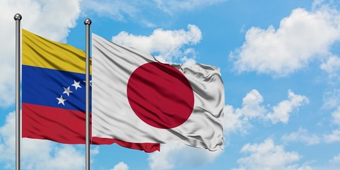 Venezuela and Japan flag waving in the wind against white cloudy blue sky together. Diplomacy concept, international relations.