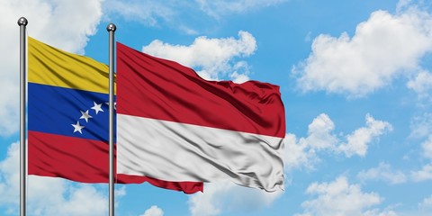 Venezuela and Monaco flag waving in the wind against white cloudy blue sky together. Diplomacy concept, international relations.