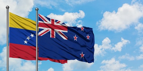 Venezuela and New Zealand flag waving in the wind against white cloudy blue sky together. Diplomacy...