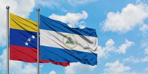 Venezuela and Nicaragua flag waving in the wind against white cloudy blue sky together. Diplomacy concept, international relations.