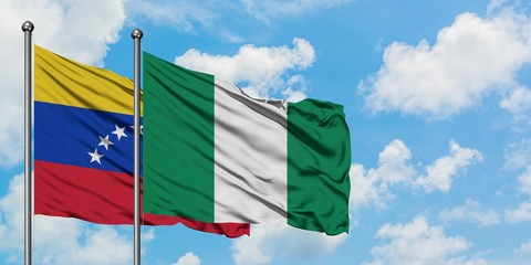 Venezuela and Nigeria flag waving in the wind against white cloudy blue sky together. Diplomacy concept, international relations.