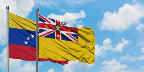 Venezuela and Niue flag waving in the wind against white cloudy blue sky together. Diplomacy concept, international relations.