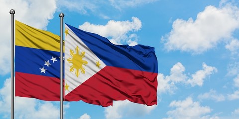 Venezuela and Philippines flag waving in the wind against white cloudy blue sky together. Diplomacy concept, international relations.