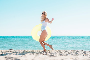 Girl goes swimming on the beach with a rubber ring