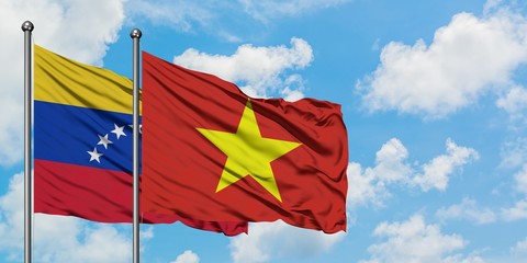 Venezuela and Vietnam flag waving in the wind against white cloudy blue sky together. Diplomacy concept, international relations.