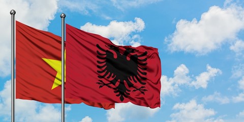 Vietnam and Albania flag waving in the wind against white cloudy blue sky together. Diplomacy concept, international relations.