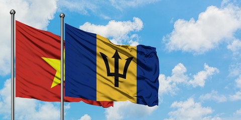 Vietnam and Barbados flag waving in the wind against white cloudy blue sky together. Diplomacy concept, international relations.