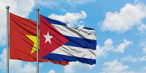 Vietnam and Cuba flag waving in the wind against white cloudy blue sky together. Diplomacy concept, international relations.