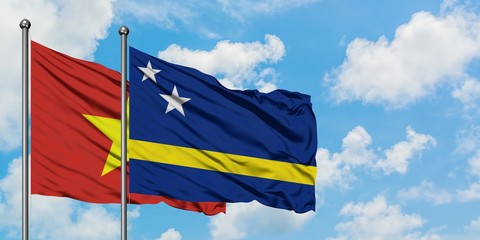 Vietnam and Curacao flag waving in the wind against white cloudy blue sky together. Diplomacy concept, international relations.