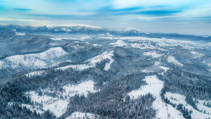 amazing winter landscape. mountains covered with snow and blue cloudy sky. drone shot,  bird's eye