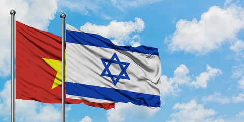 Vietnam and Israel flag waving in the wind against white cloudy blue sky together. Diplomacy concept, international relations.