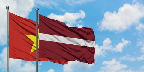 Vietnam and Latvia flag waving in the wind against white cloudy blue sky together. Diplomacy concept, international relations.