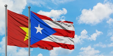 Vietnam and Puerto Rico flag waving in the wind against white cloudy blue sky together. Diplomacy concept, international relations.