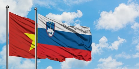 Vietnam and Slovenia flag waving in the wind against white cloudy blue sky together. Diplomacy concept, international relations.