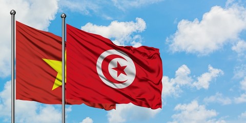 Vietnam and Tunisia flag waving in the wind against white cloudy blue sky together. Diplomacy concept, international relations.