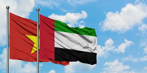 Vietnam and United Arab Emirates flag waving in the wind against white cloudy blue sky together. Diplomacy concept, international relations.
