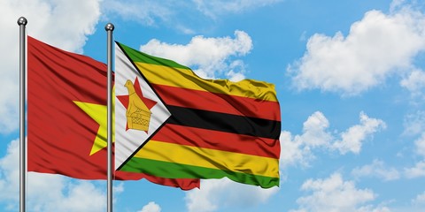 Vietnam and Zimbabwe flag waving in the wind against white cloudy blue sky together. Diplomacy concept, international relations.