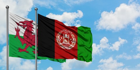 Wales and Afghanistan flag waving in the wind against white cloudy blue sky together. Diplomacy concept, international relations.