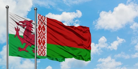 Wales and Belarus flag waving in the wind against white cloudy blue sky together. Diplomacy...
