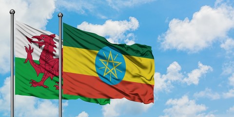Wales and Ethiopia flag waving in the wind against white cloudy blue sky together. Diplomacy concept, international relations.