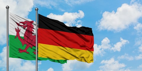 Wales and Germany flag waving in the wind against white cloudy blue sky together. Diplomacy concept, international relations.