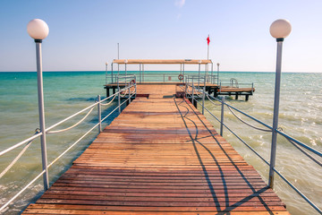 Naklejka premium Wooden pier, weak water waves in the Mediterranean Sea, holiday scenes with a sense of calm.