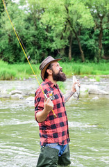 Fishing masculine hobby. Fishing requires you to be mindful and fully present in moment. Fisher fishing equipment. Fish on hook. Brutal man wear rubber boots stand in river water. Weekend activity
