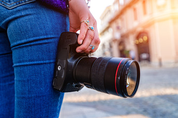 Person taking pictures with dslr camera and lens during walking around european city