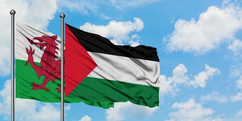 Wales and Palestine flag waving in the wind against white cloudy blue sky together. Diplomacy concept, international relations.