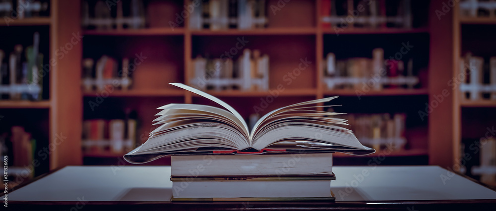 Poster stack of books in the library and blur bookshelf background