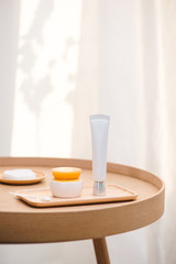 Cosmetic bottle containers on white wooden table top view flat laye. Blank label for branding mock-up Natural beauty product concept Shower Gel Soap Cream