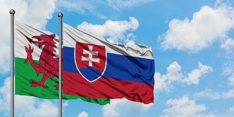Wales and Slovakia flag waving in the wind against white cloudy blue sky together. Diplomacy concept, international relations.