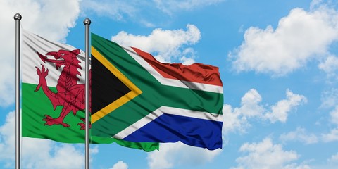 Wales and South Africa flag waving in the wind against white cloudy blue sky together. Diplomacy concept, international relations.