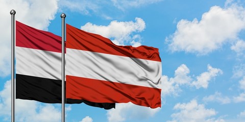 Yemen and Austria flag waving in the wind against white cloudy blue sky together. Diplomacy concept, international relations.