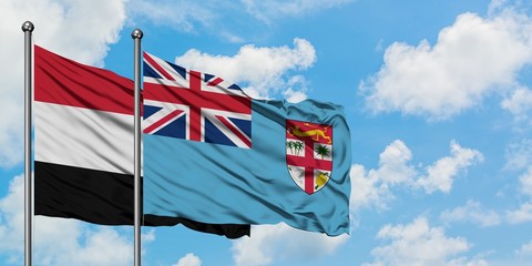 Yemen and Fiji flag waving in the wind against white cloudy blue sky together. Diplomacy concept, international relations.