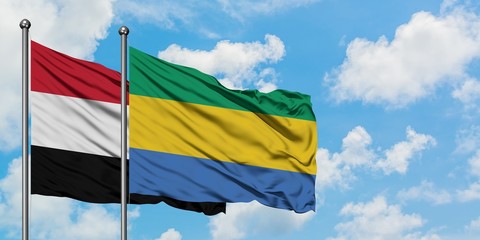 Yemen and Gabon flag waving in the wind against white cloudy blue sky together. Diplomacy concept, international relations.
