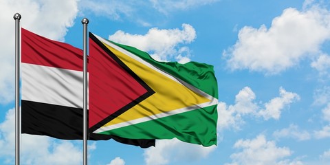 Yemen and Guyana flag waving in the wind against white cloudy blue sky together. Diplomacy concept, international relations.