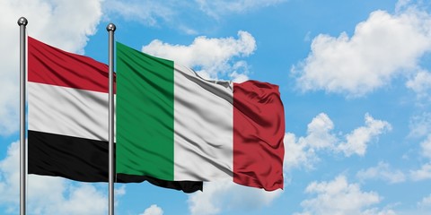 Yemen and Italy flag waving in the wind against white cloudy blue sky together. Diplomacy concept, international relations.