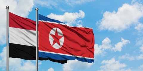 Yemen and North Korea flag waving in the wind against white cloudy blue sky together. Diplomacy concept, international relations.