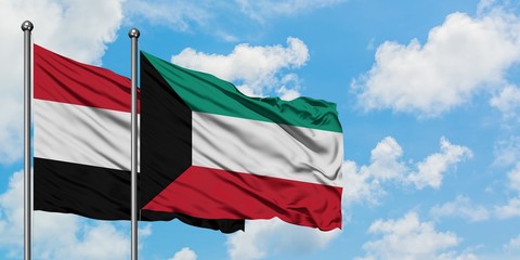 Yemen and Kuwait flag waving in the wind against white cloudy blue sky together. Diplomacy concept, international relations.