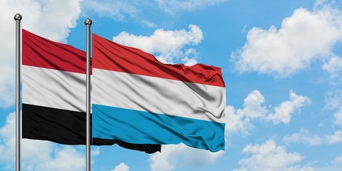 Yemen and Luxembourg flag waving in the wind against white cloudy blue sky together. Diplomacy concept, international relations.