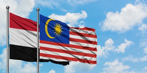 Yemen and Malaysia flag waving in the wind against white cloudy blue sky together. Diplomacy concept, international relations.