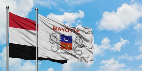Yemen and Mayotte flag waving in the wind against white cloudy blue sky together. Diplomacy...