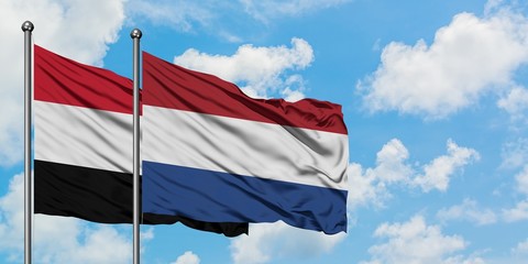 Yemen and Netherlands flag waving in the wind against white cloudy blue sky together. Diplomacy concept, international relations.